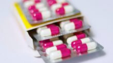 white and red medication pill on yellow box