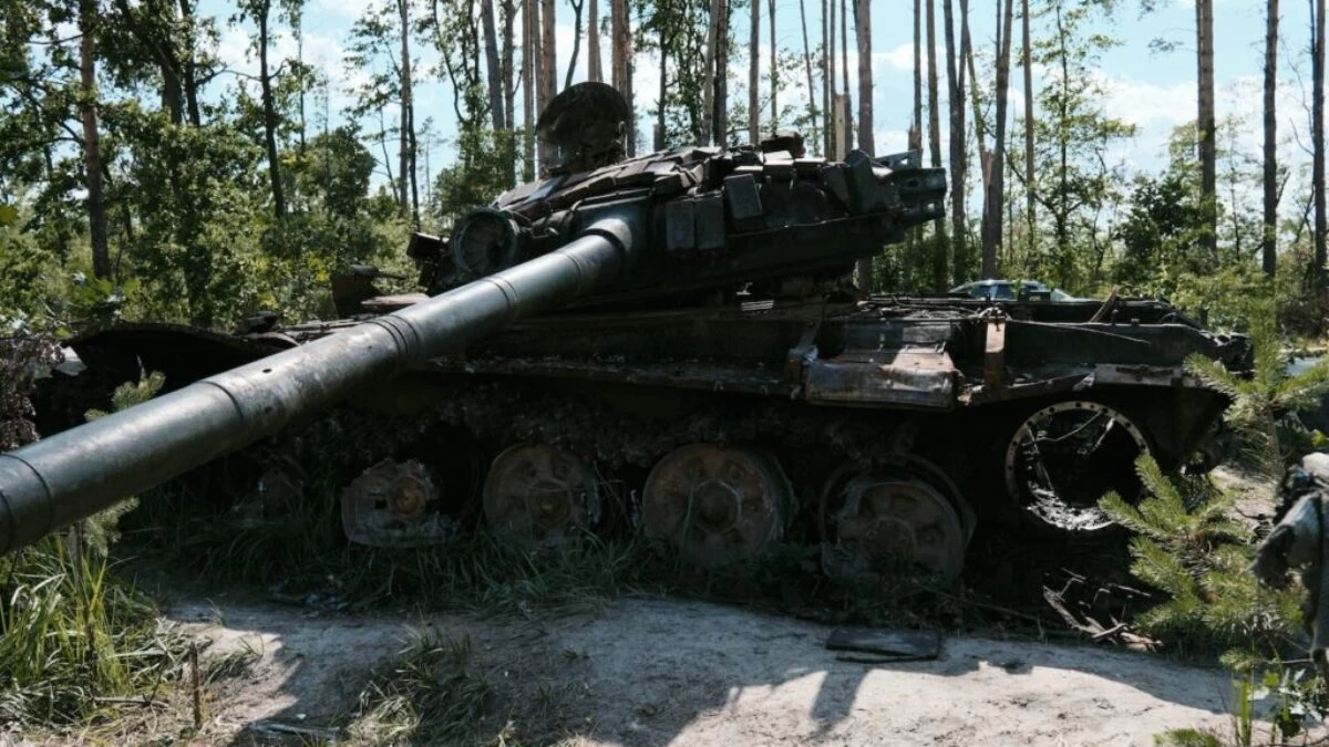an old tank sitting in the middle of a forest
