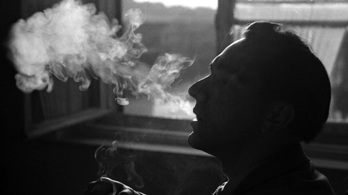 person smoking beside window