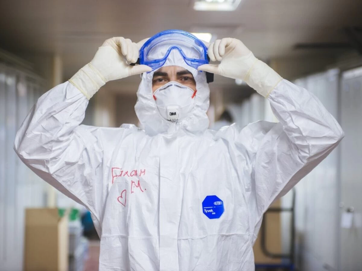person in white and blue mask and white long sleeve shirt