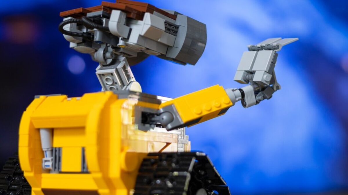 a yellow and black lego robot with a blue background