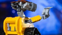 a yellow and black lego robot with a blue background