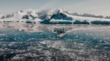 a large body of water surrounded by snow covered mountains