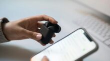 A Person Holding Wireless Earphones and a Smartphone