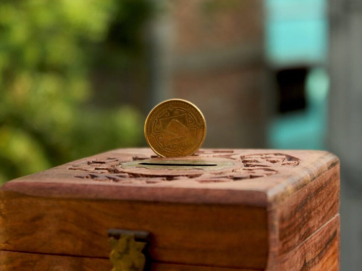Gold Round Coin on Brown Wooden Piggy Bank