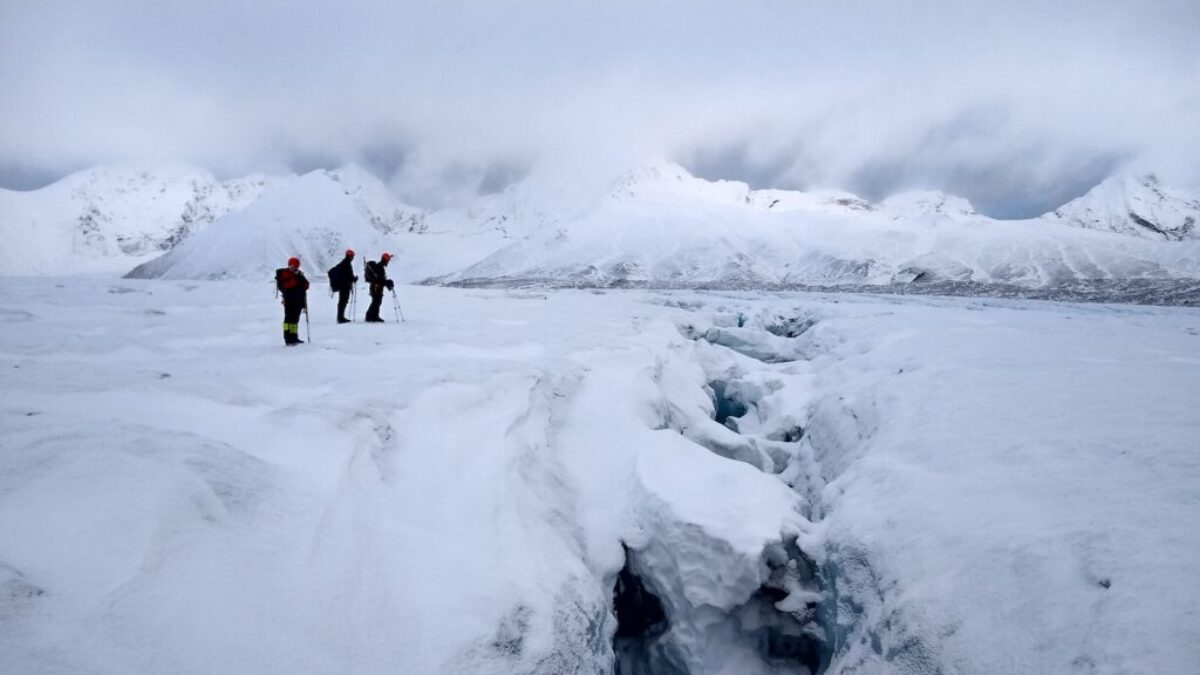 2 person walking on snow covered ground during daytime