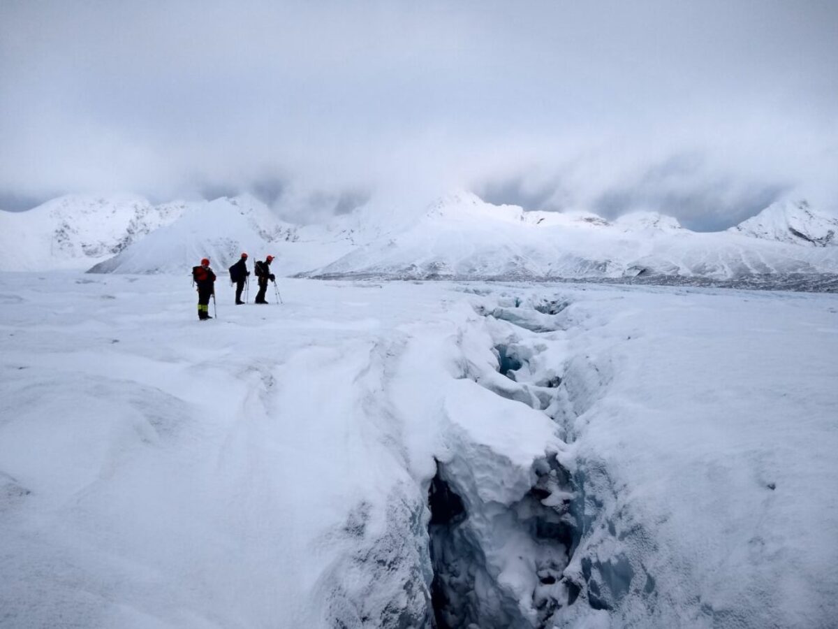 2 person walking on snow covered ground during daytime