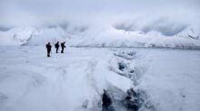 2 person walking on snow covered ground during daytime