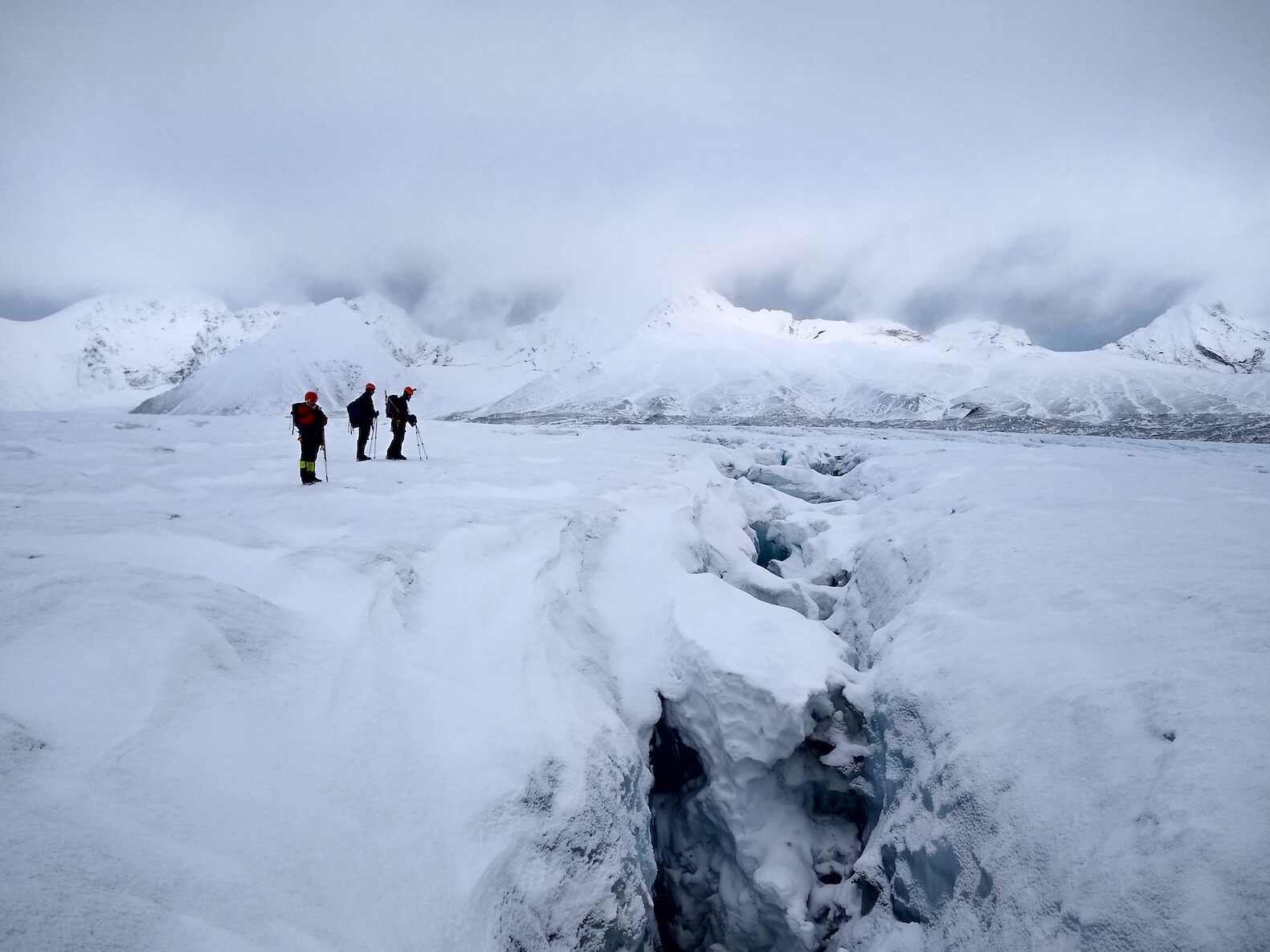 2 person walking on snow covered ground during daytime