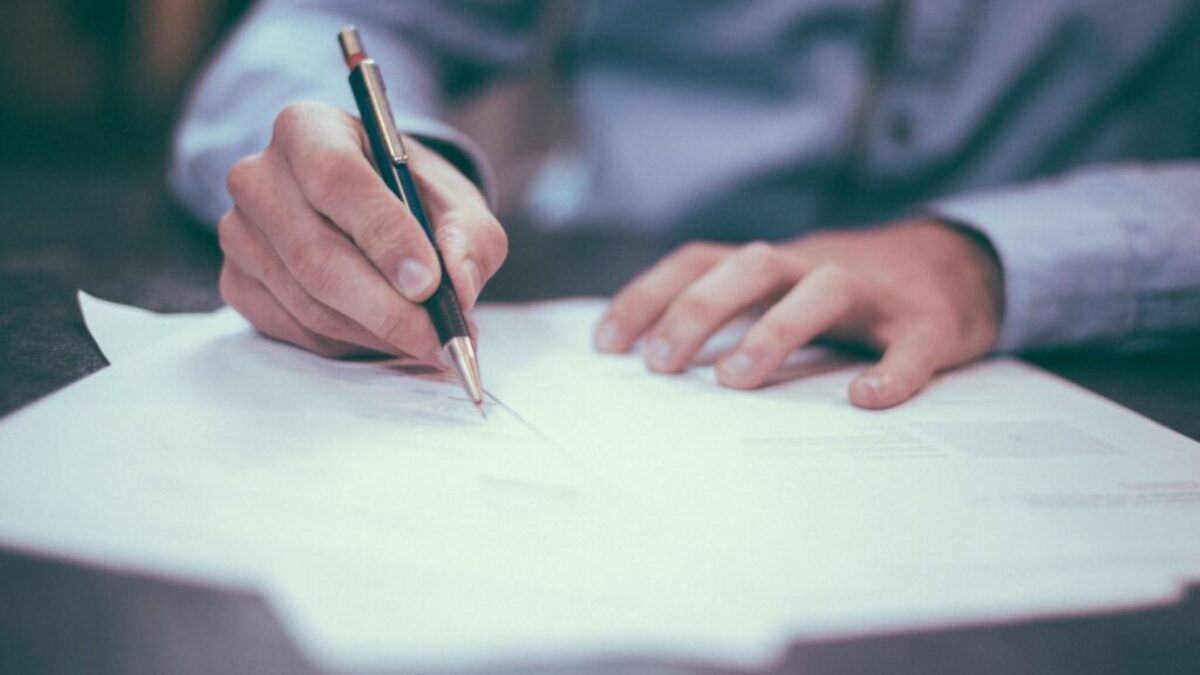 man writing on paper