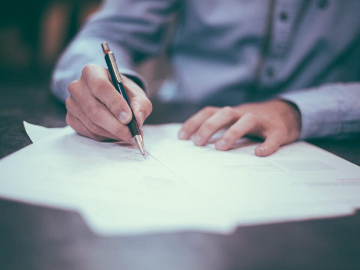 man writing on paper