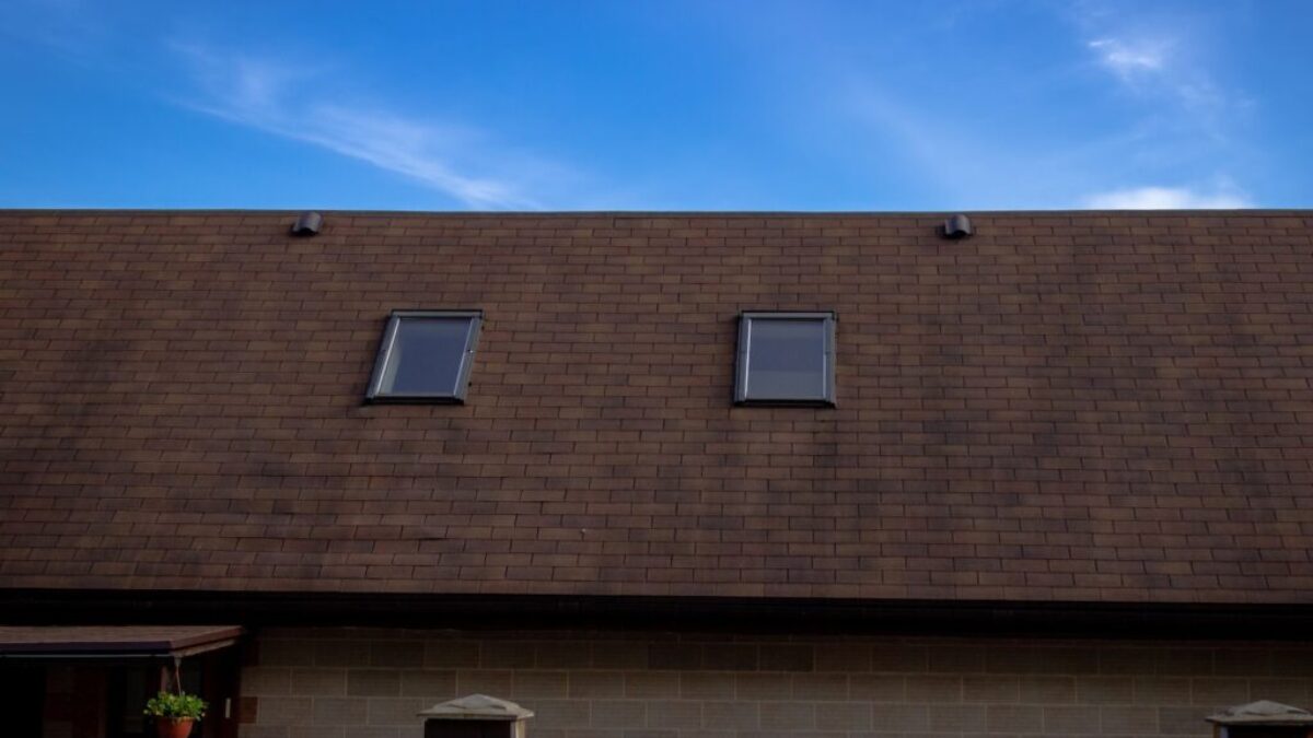 a house with two windows and a brown roof