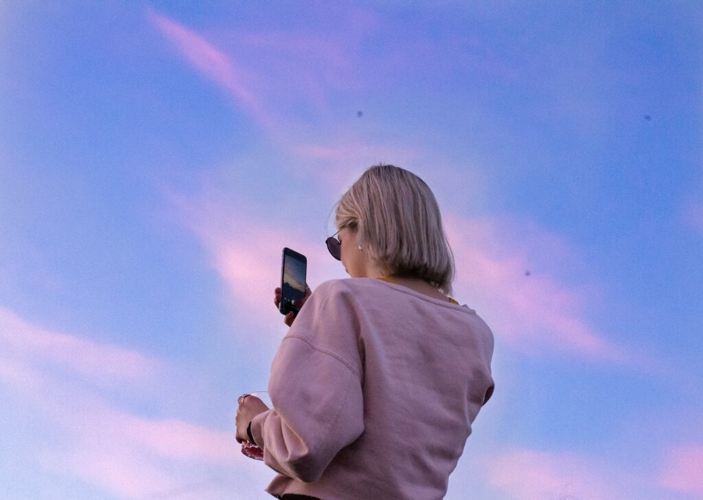 Photo by Marie-Michèle Bouchard - Techsvět woman in sunglasses and pink top holding phone