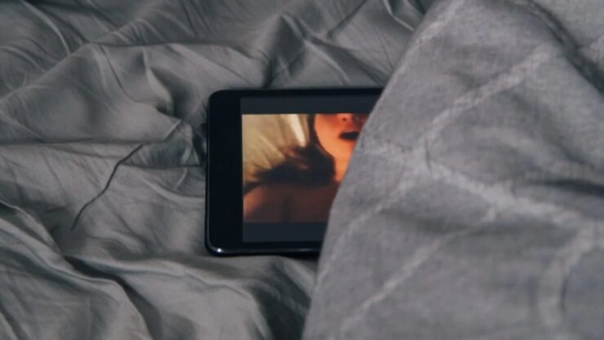 black Android smartphone on gray bed sheet