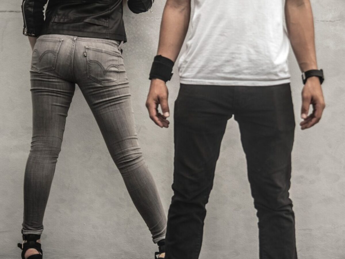 man in black pants beside woman in gray skinny jeans