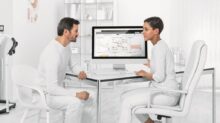 man in white dress shirt sitting on white chair in front of computer