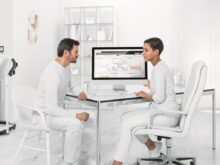 man in white dress shirt sitting on white chair in front of computer