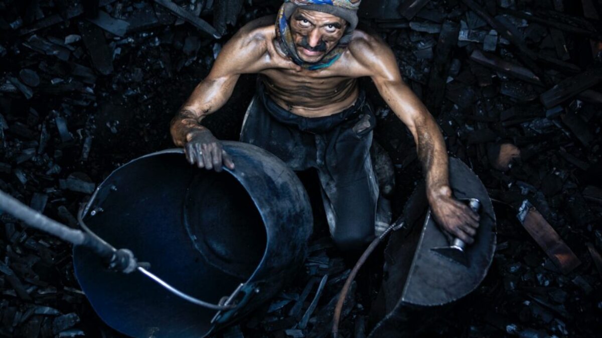 a man with a mask on holding a bucket