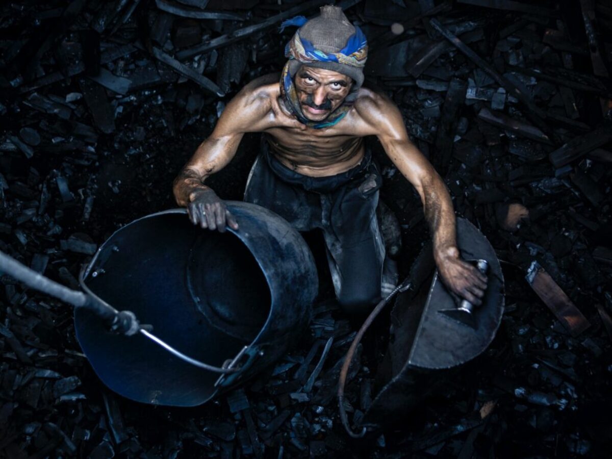 a man with a mask on holding a bucket