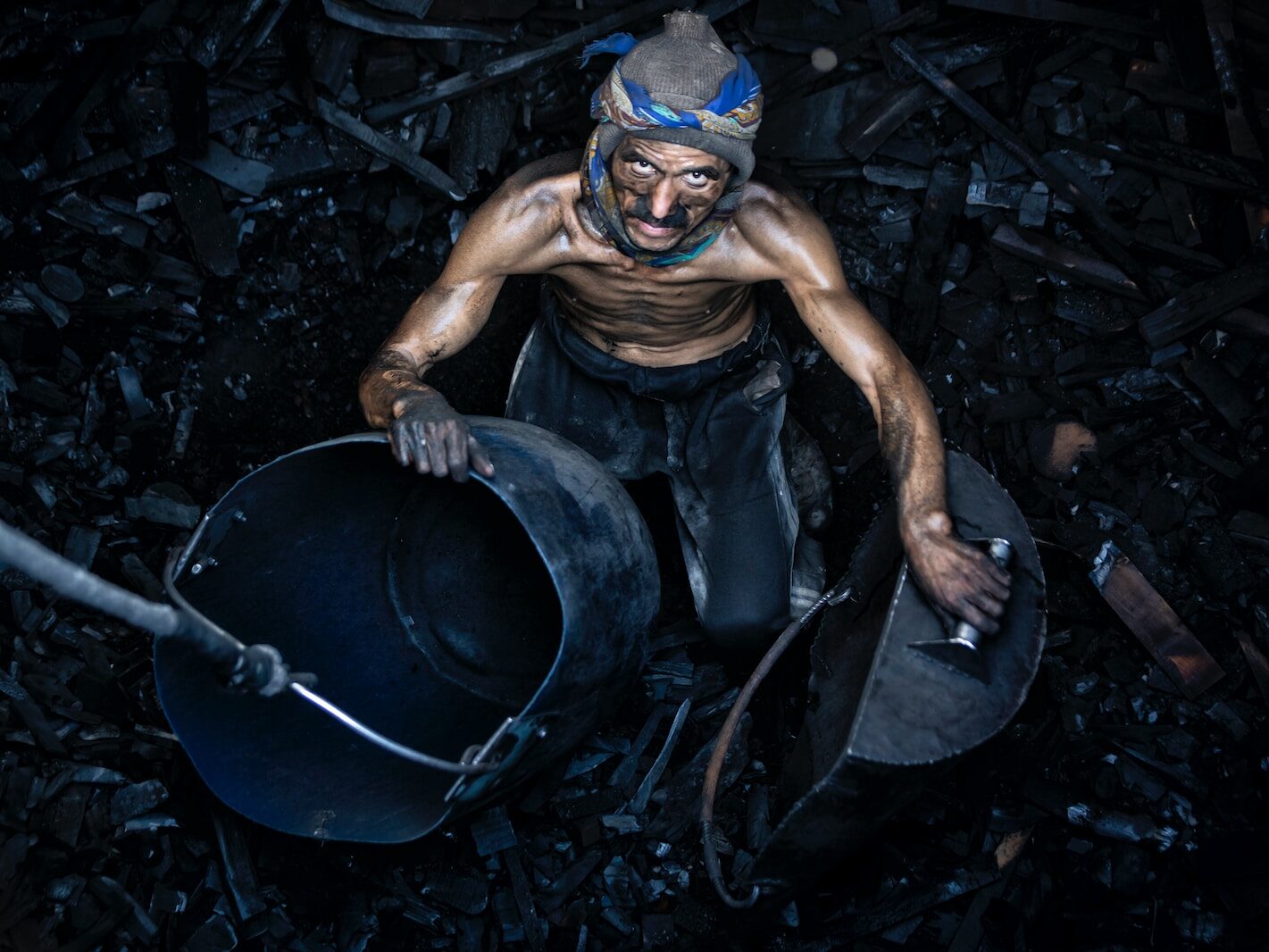 a man with a mask on holding a bucket