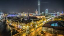 time-lapse photography of vehicle at the road in between the building at nighttime aerial photography