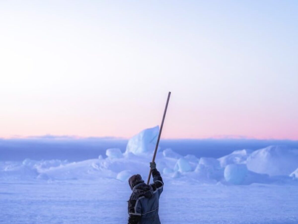 person in black winter jacket holding black stick on snow covered ground during daytime