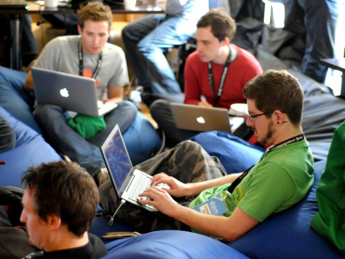 man sitting on blue bean bag usinglaptop
