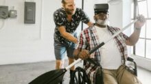 Man Helping a Man Play with Virtual Reality Headset