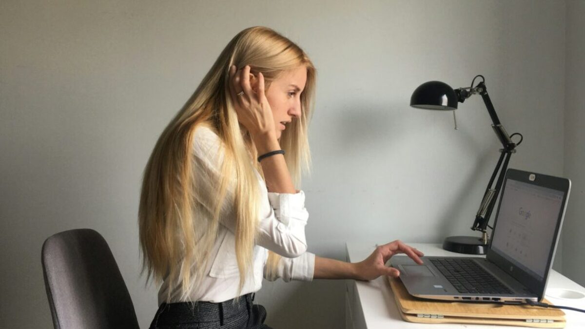 woman in white long sleeve shirt and black pants sitting on black office rolling chair