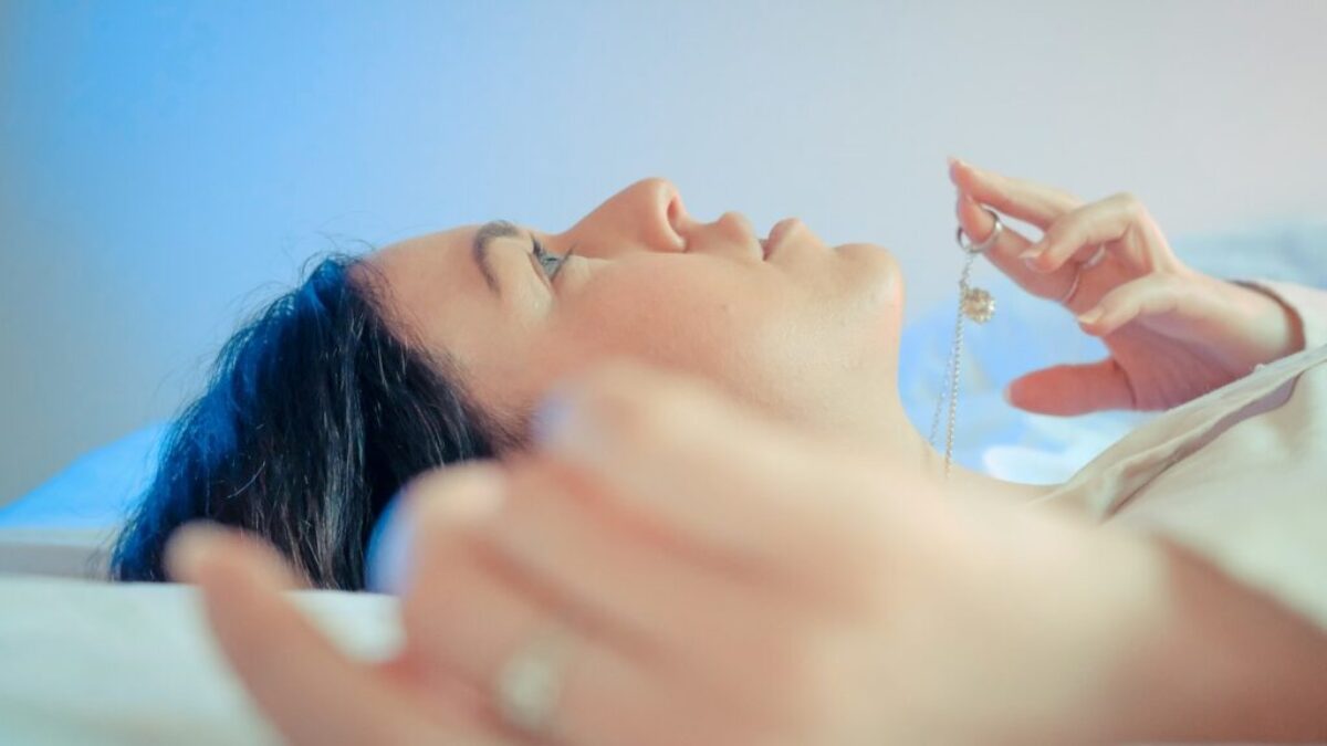 woman lying on bed with her hand on her face