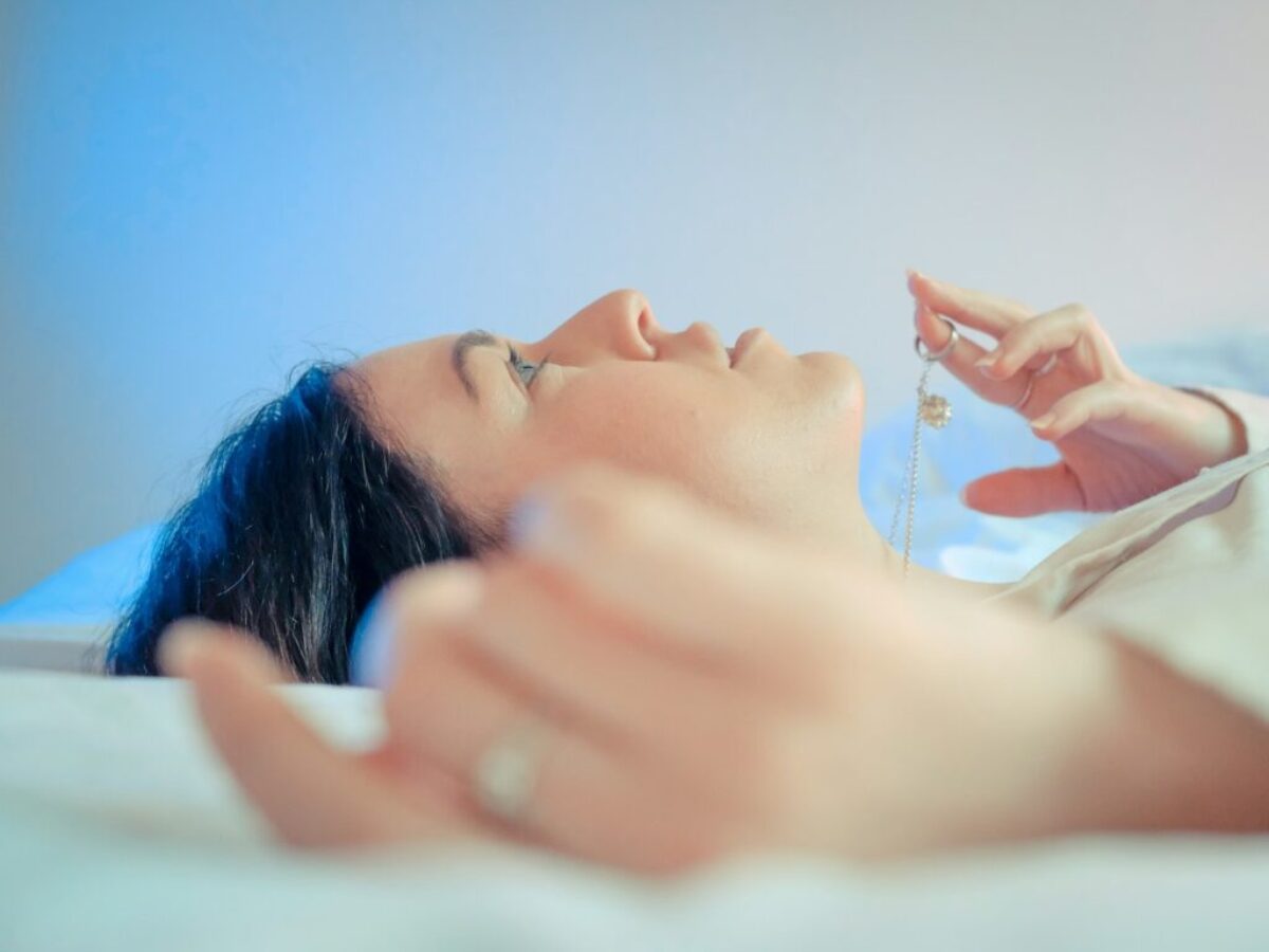woman lying on bed with her hand on her face