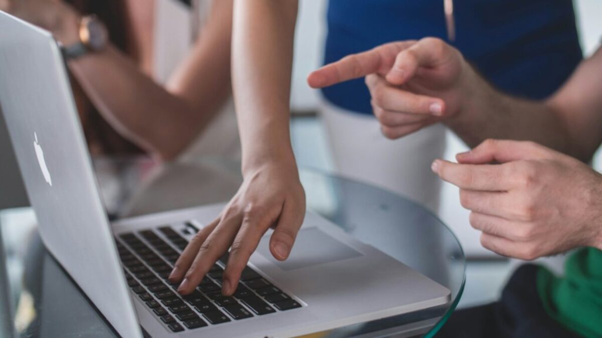 person touching and pointing MacBook Pro