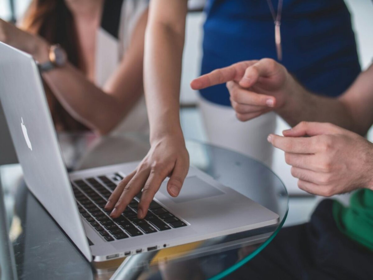 person touching and pointing MacBook Pro