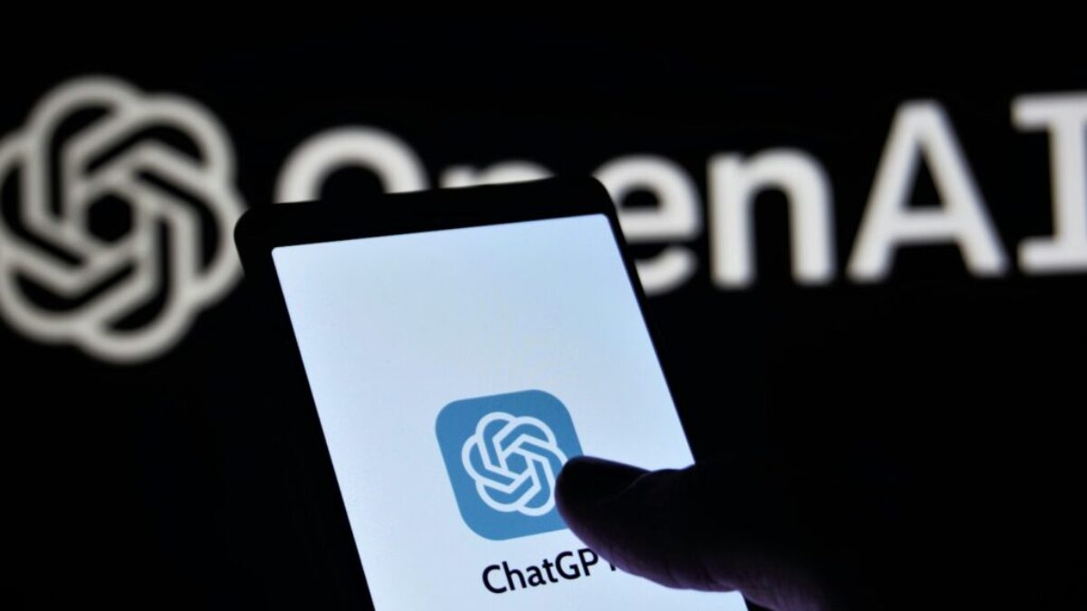 a person holding a cell phone in front of a logo