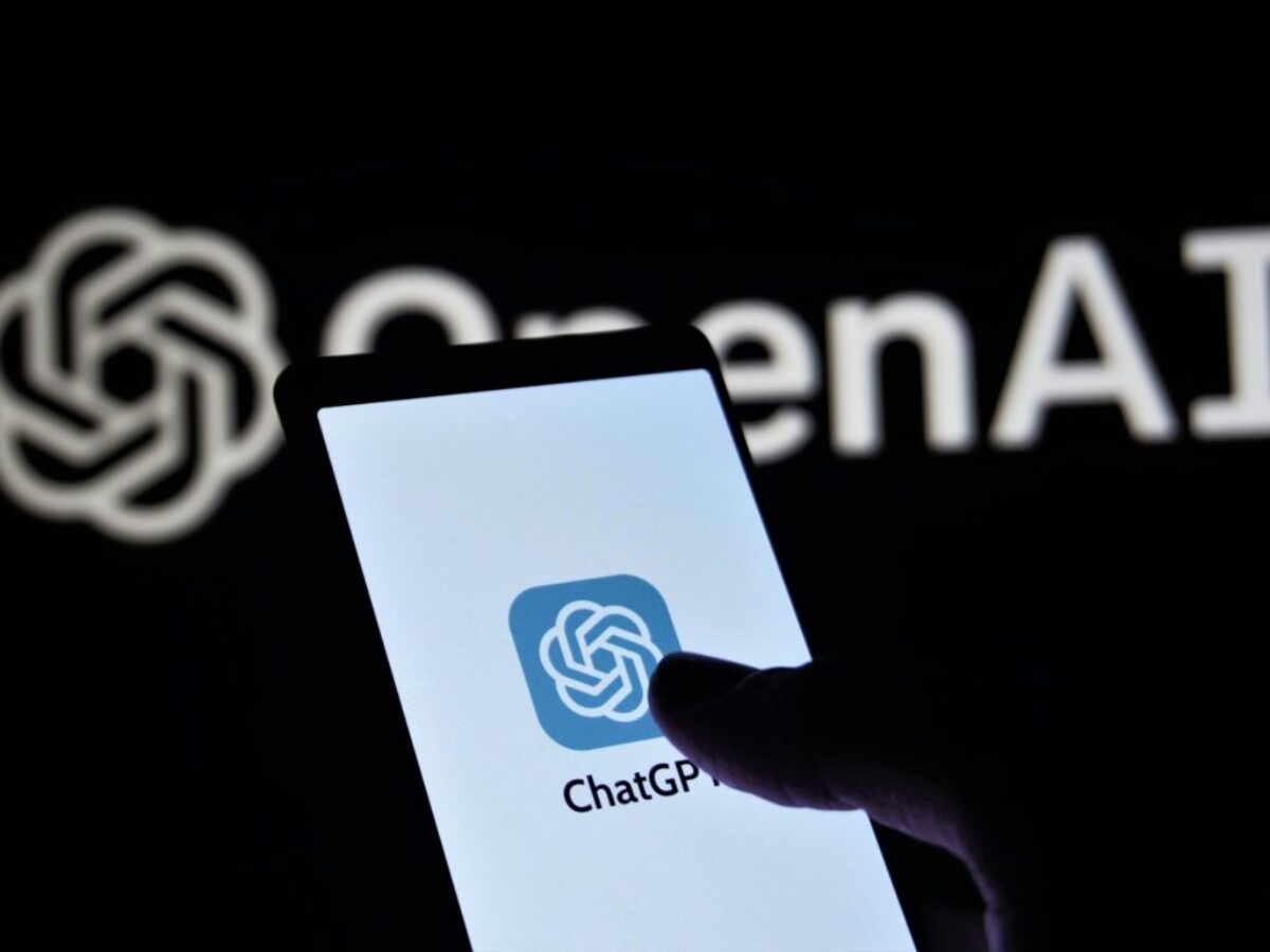 a person holding a cell phone in front of a logo