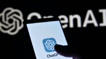a person holding a cell phone in front of a logo