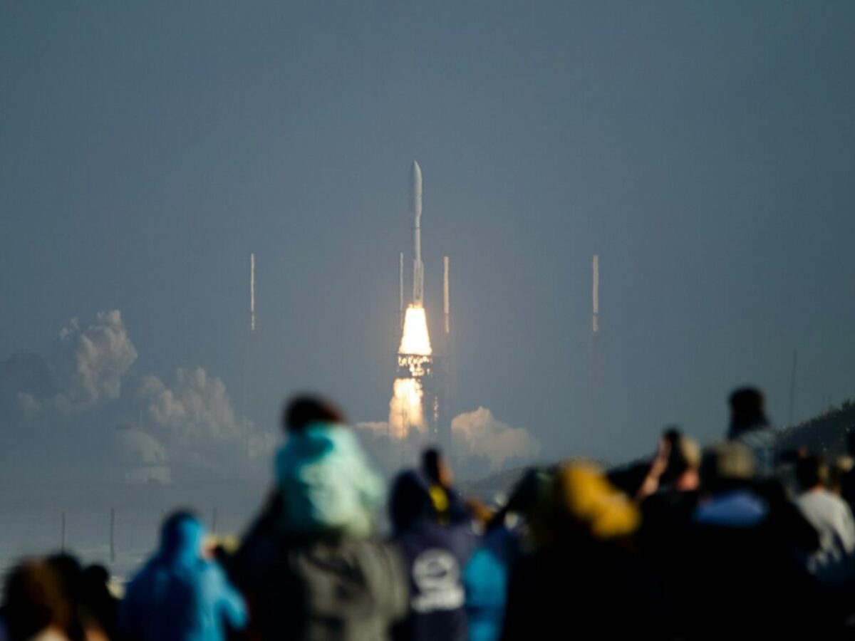 a crowd of people watching a rocket launch