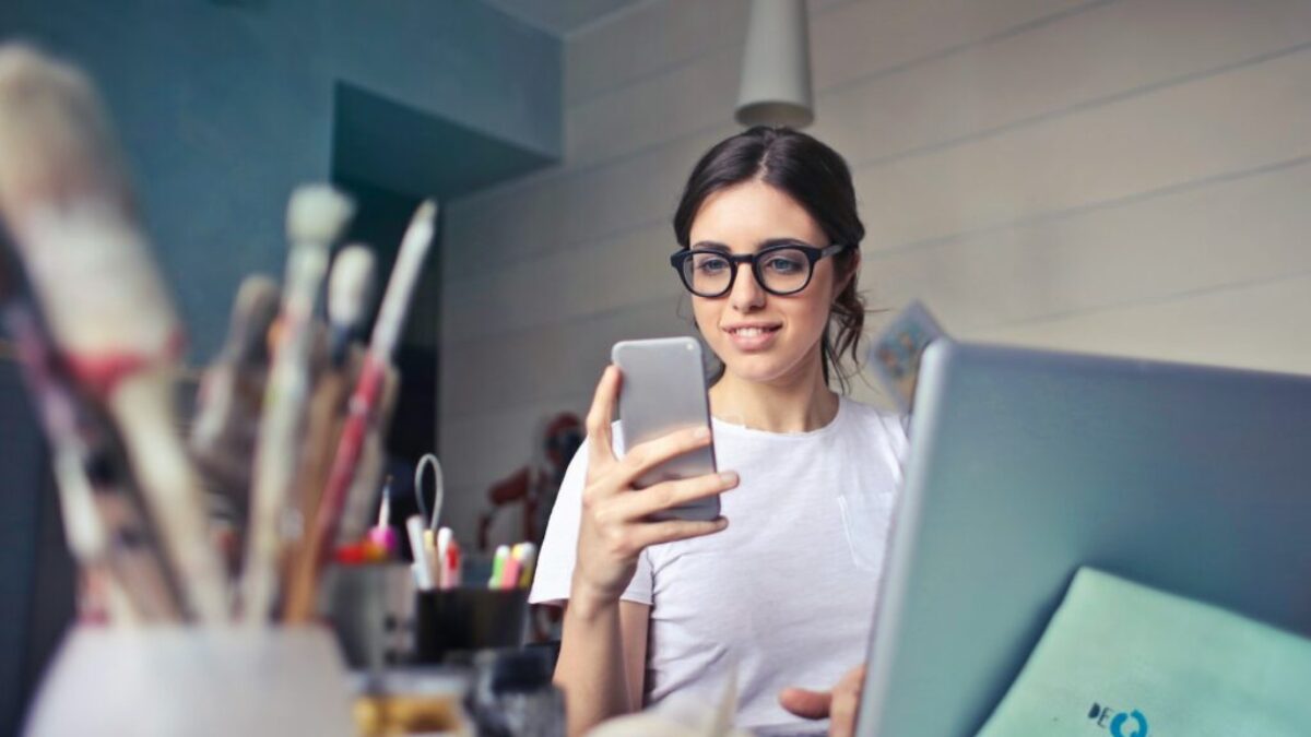 woman in white shirt using smartphone