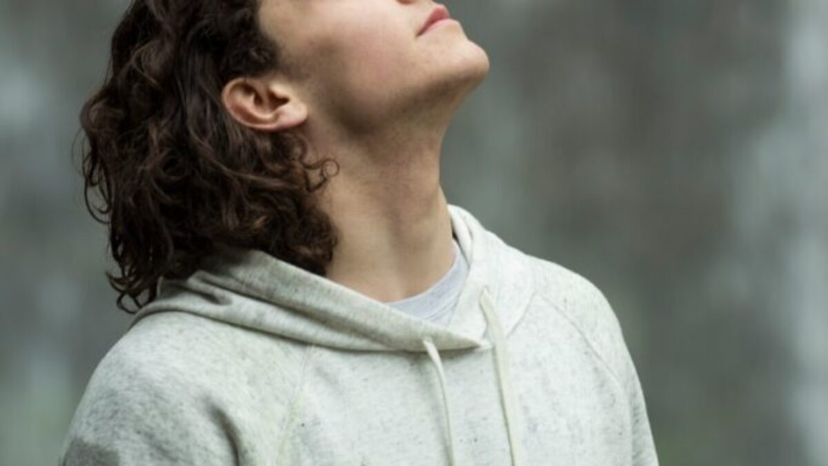 man in gray pullover hoodie closed eyes while heads up