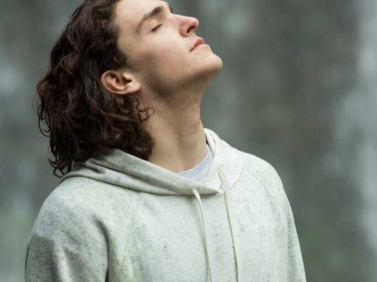 man in gray pullover hoodie closed eyes while heads up