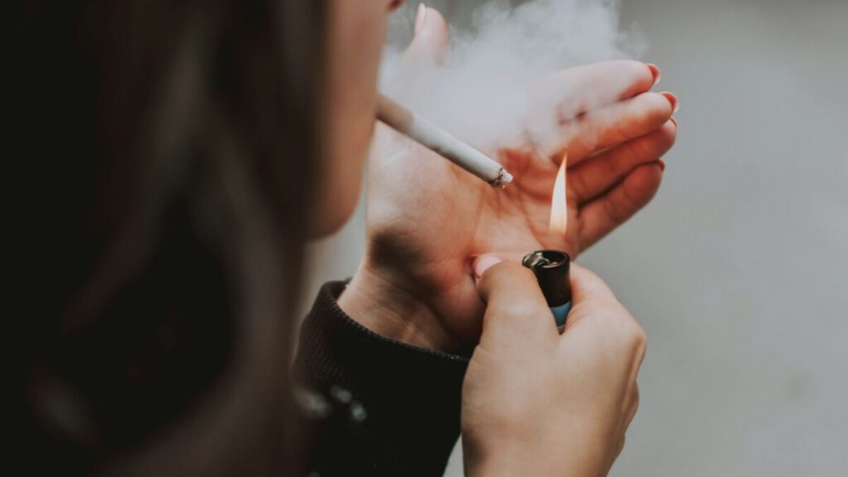 woman lights her cigarette with lighter