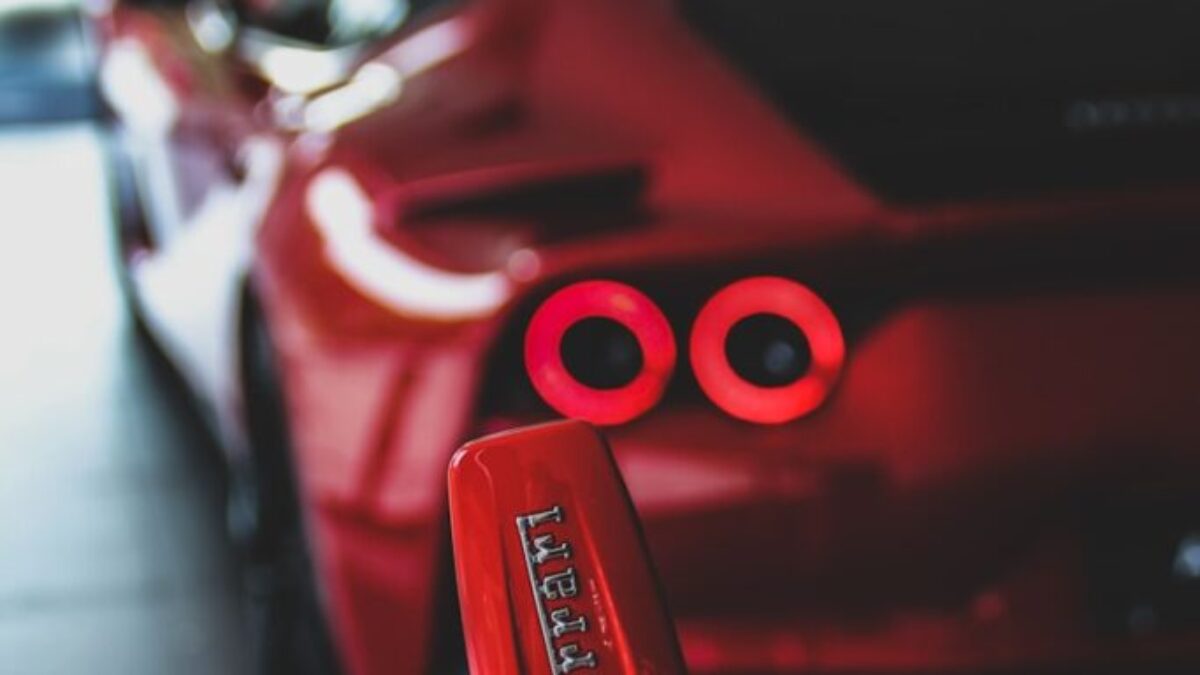 red person with keyfob of red Ferrari supercar