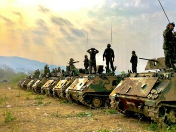 soldiers on top of battle tanks