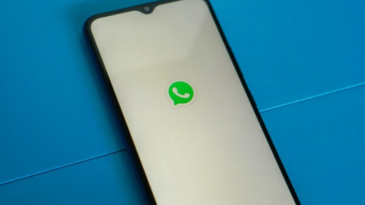 a white and black phone with a green whatsapp sticker on it