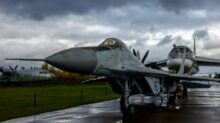 a fighter jet sitting on top of an airport tarmac