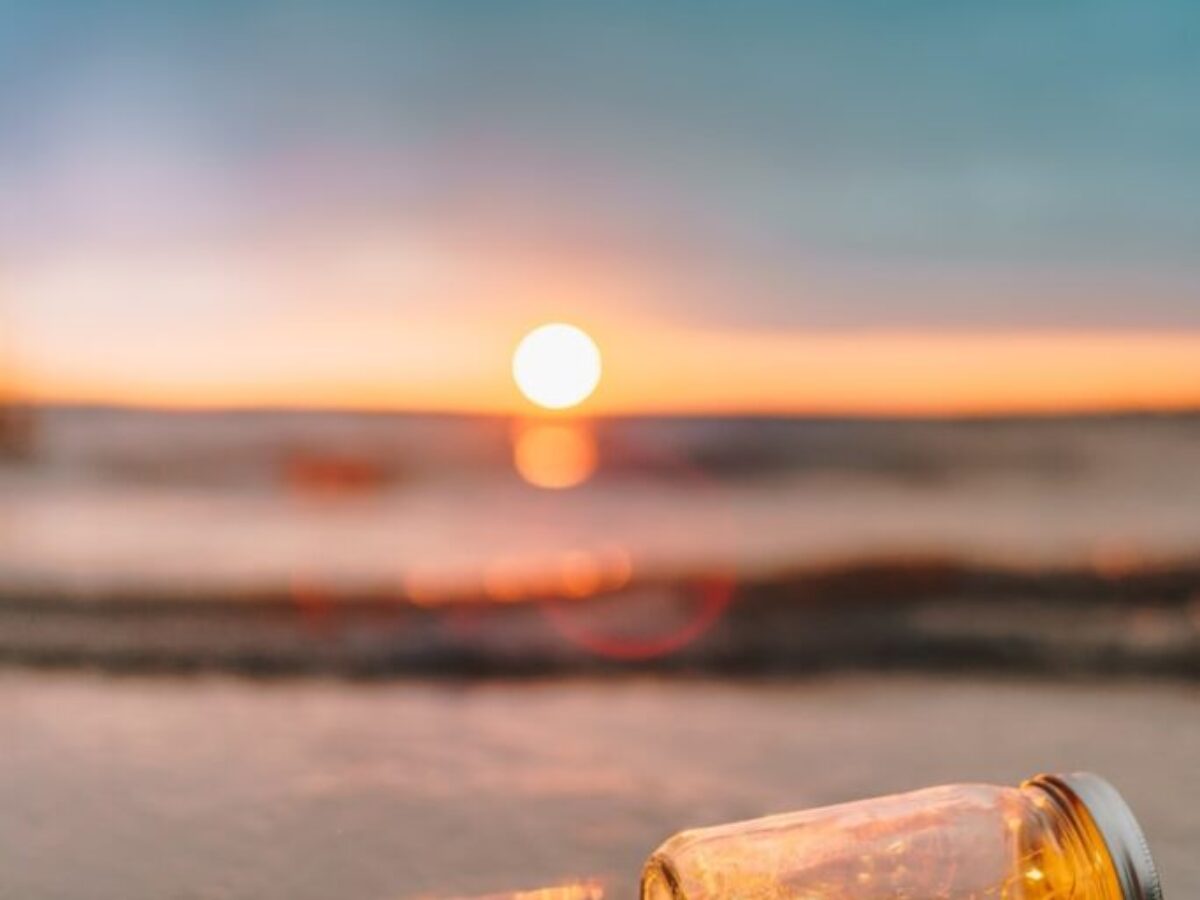 clear glass mason jar on beach during sunset