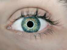 person showing green and black eyelid closeup photography