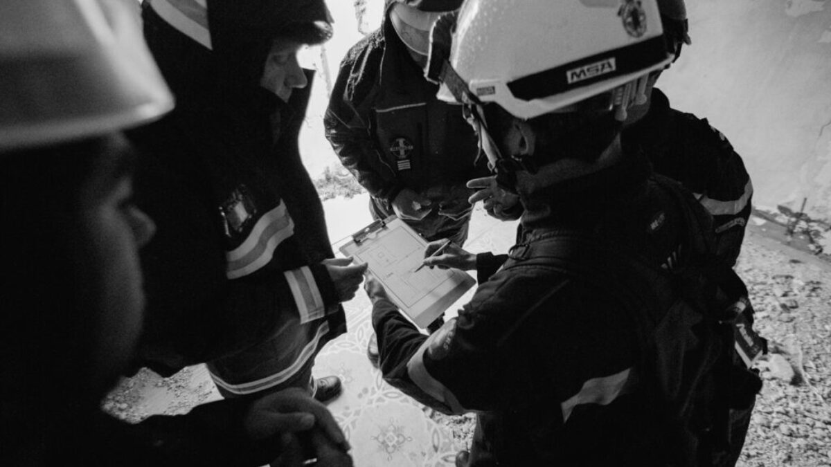 grayscale photo of 2 men in black jacket and helmet