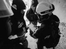 grayscale photo of 2 men in black jacket and helmet