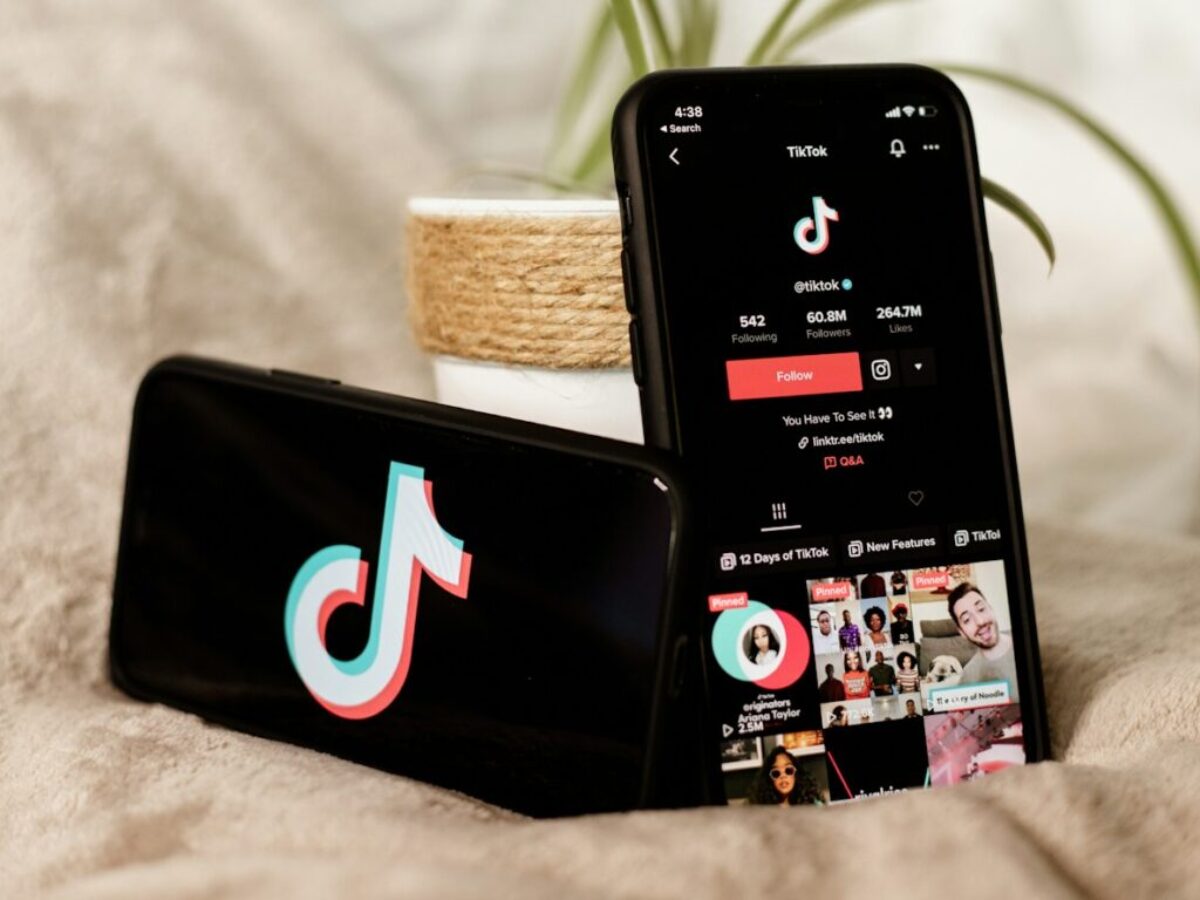 a couple of cell phones sitting on top of a bed